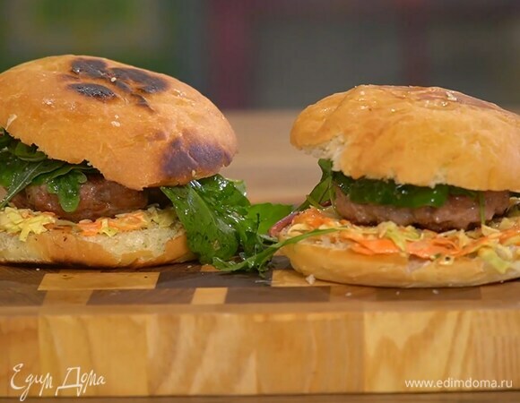 На нижнюю часть каждой булочки выложить морковно-капустный салат, котлету, листья салата и накрыть второй половинкой булки.
