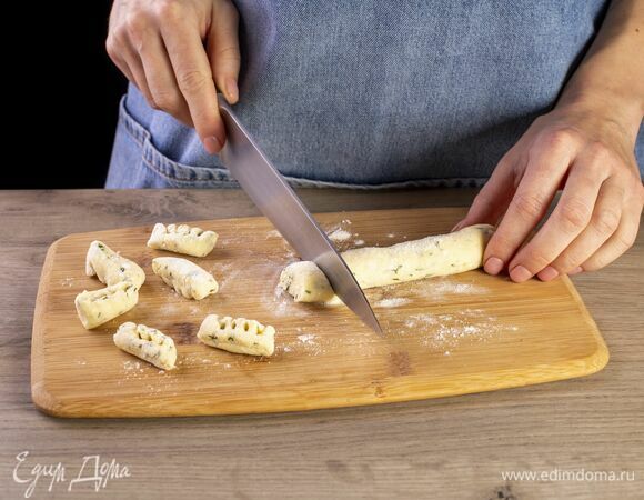 Из теста скатайте колбаску и нарежьте ее небольшими кусочками. Из каждого сформируйте ньокки, прокатав вилкой.