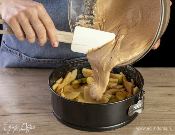 По кругу выложите в форму яблоки, залейте тестом. Выпекайте в заранее разогретой до 180°C духовке 40 минут.