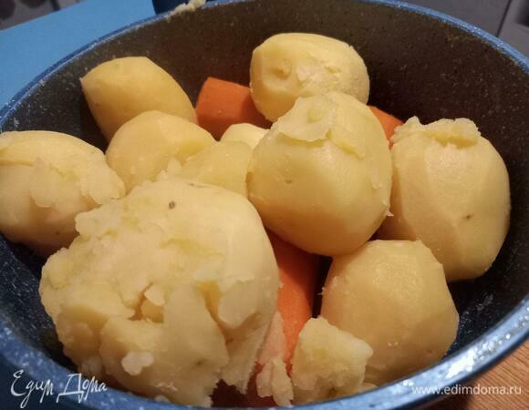 Готовность картофеля можно проверить ножом или вилкой, слегка проткнув. Картофель должен легко рассыпаться и стать мягким. Если готов картофель, морковь тоже готова. Слить жидкость, в которой варились овощи, в отдельную чашу.