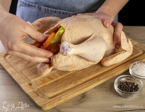 Курицу посолите, поперчите и начините ароматными яблоками с курагой.