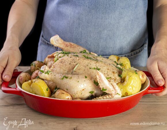 Переложите курицу на противень. Добавьте картошку, моченые яблоки и розмарин.<br />
Запекайте в духовке 1 час при 180°C. Каждые 20 минут поливайте маслом.