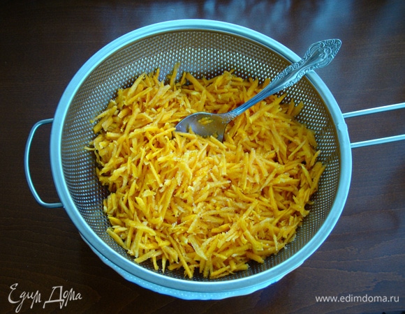 Пока тесто набирается клейковины, приготовим начинку. Для этого натереть тыкву на терке, смешать с сахаром и переложить начинку в дуршлаг, чтобы стекал образовавшийся сок.