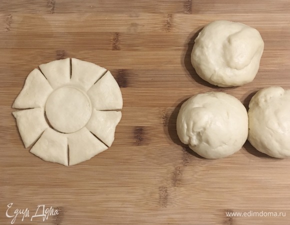 Каждый шарик руками расплющить в лепешку, в центре сделать углубление, а по краям ножом — восемь насечек.