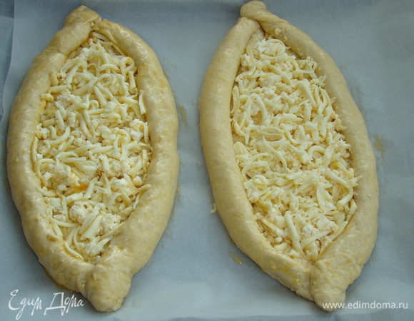 Сформировать хачапури в виде лодочки, смазать яйцом и поставить в разогретую до 180°C духовку минут на 15–20.