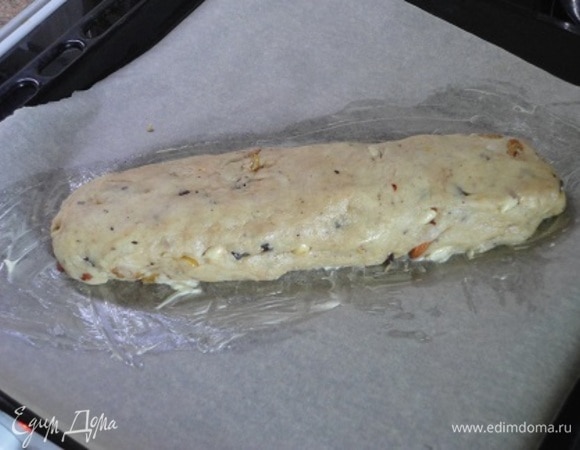 Бумагу для выпечки смазать сливочным маслом. Выложить на него сформированный из теста рулет.