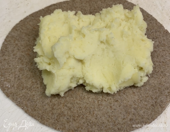 Каждый шарик раскатываем толщиной 1–1,5 мм. В середину кладем картофель так, чтобы края оставались свободными, нам они понадобятся для формирования пирожка.