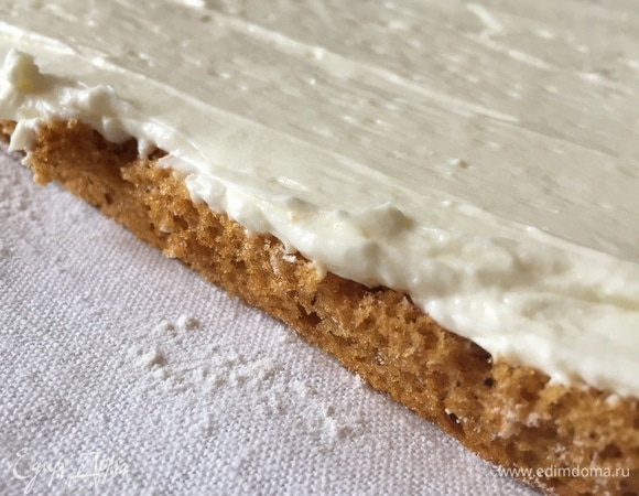Разверните рулет. Равномерно распределители крем-чиз по всей поверхности бисквитного полотна.