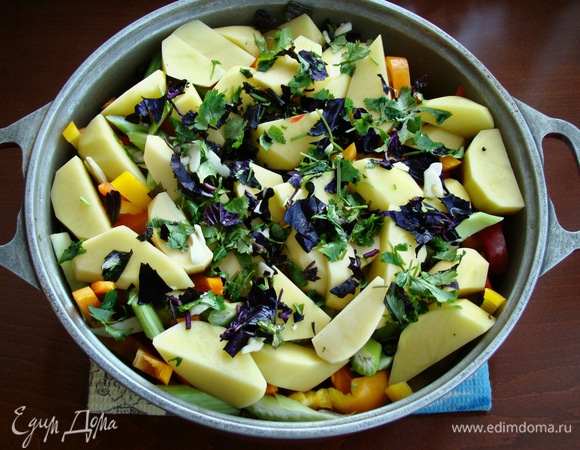 Завершает очередность картофель, нарезанный на крупные ломтики. Сверху уложить часть зелени кинзы и базилика, оставшуюся часть чеснока, посолить и поперчить. Влить оставшуюся часть пива, накрыть крышкой и довести до кипения. Огонь убавить и тушить в течение 30 минут.