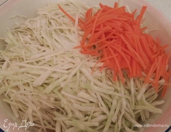 В эмалированную чашу складываю по частям капусту, морковь, посыпаю солью и щепоткой сахара, перемешиваю, обминаю.