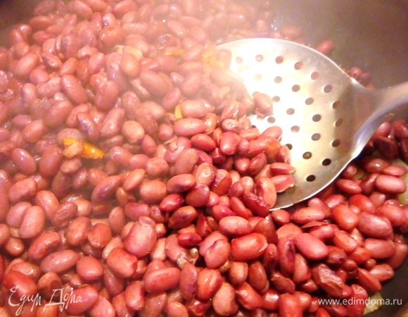 Добавляем к луку и моркови отварную фасоль, перемешиваем, тушим минут 15.