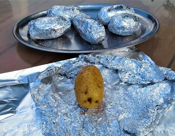 Картошку тщательно помыть губкой. Фольгу для запекания смазать растительным маслом и посолить. Завернуть картошку в два слоя фольги.