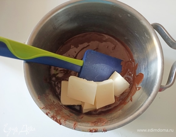 К шоколаду добавить сливочное масло комнатной температуры и перемешать.