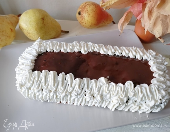 В сотейник влить молоко, поставить на огонь и довести почти до кипения. Измельчить шоколад (50 г), добавить в горячее молоко, перемешать до полного растворения шоколада. Остудить. Взбить хорошо охлажденные сливки. Верх кекса смазать шоколадом и украсить взбитыми сливками. Приятного аппетита!