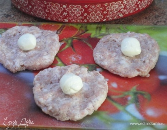 В свиной фарш я добавила только соль и черный свежемолотый перец. Слегка отбиваем, чтобы он не развалился при жарке. Формируем лепешки и выкладываем на каждую по шарику моцареллы (у автора — сулугуни). Формируем шарики.