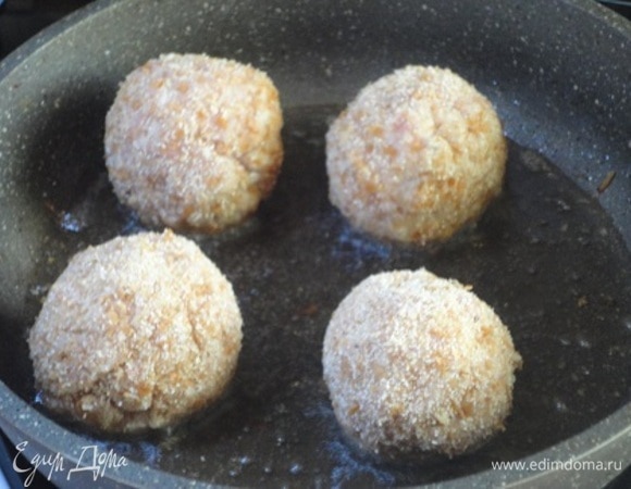 Обваливаем их в панировочных сухарях и слегка обжариваем в горячем растительном масле. Выкладываем в форму для запекания, наливаем пару ложек воды, закрываем фольгой и готовим в духовке 10–15 минут при 180–200°C (до готовности).