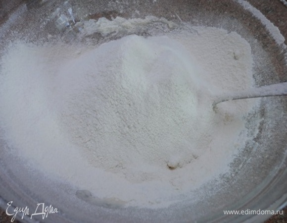 Смешаем в миске сухие ингредиенты: пшеничную и цельнозерновую муку, сухие дрожжи, соль. Начинаем аккуратно перемешивать массу сначала ложкой. А потом, когда тесто станет плотным, вымешиваем вручную.