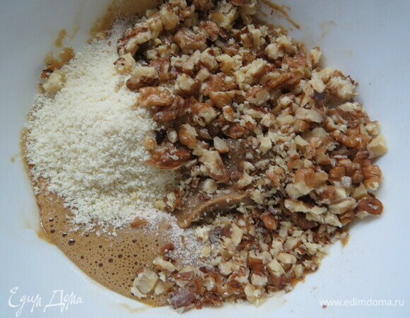 Духовку разогреть до 180°C. Подготовить форму, смазав маслом. Орехи для теста перемолоть в очень мелкую крошку. Желтки смешать с сахаром, добавить муку (гречневую можно заменить на обычную или цельнозерновую) и молотые орехи, замесить тесто.