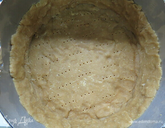 Раскатайте тесто толщиной примерно 3 мм. Вырежьте круг диаметром 19 см. Постелите на противень пекарскую бумагу, положите кольцо, на дно кольца — круг теста. Нарежьте полоски шириной 2,5 см и уложите бока формы. Прижмите ко дну и стенкам. Уберите в холодильник минимум на 30 мин. Чем дольше тесто стоит в холоде, тем меньше усадка теста при выпечке. Наколите вилкой по всему периметру тарта. Разогрейте духовку до 180°C. Достаньте форму с тартом из холодильника. Уложите внутрь формы бумагу для выпечки, насыпьте сверху рис до самого верха. Выпекайте примерно 15 мин. Достаньте из духовки, аккуратно уберите пленку с рисом (я ничего не насыпала, так испекла, все нормально). Дайте остыть.