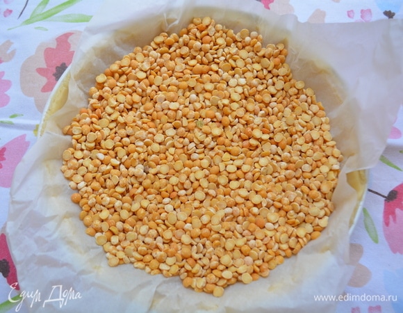 На тесто уложить пекарскую бумагу, высыпать сухой горох или фасоль. Выпекать 15 минут. Выпеченный корж достать из духовки. Бумагу с горохом удалить.