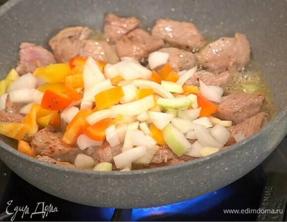 В сковороду с мясом добавить нарезанные овощи, все перемешать и обжарить.