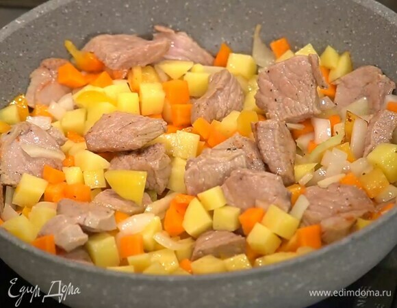 Картофель и морковь почистить, нарезать небольшими кубиками и добавить к мясу, все перемешать, посыпать смесью перца и кориандра, немного обжарить, затем влить горячий бульон.