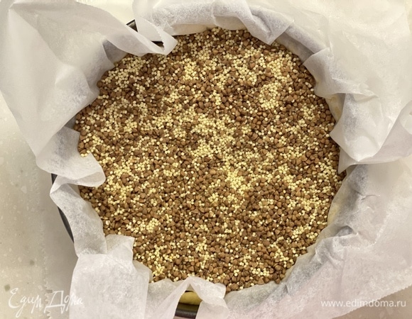 Вынуть из холодильника, проткнуть вилкой, застелить пергаментом и засыпать грузом. Выпекать 12 минут. Удалить бумагу и груз и выпекать еще 15–20 минут.