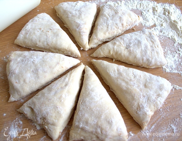 Постоявшее тесто переносим на стол с мукой, приплюснем в лепешку и делим на части.