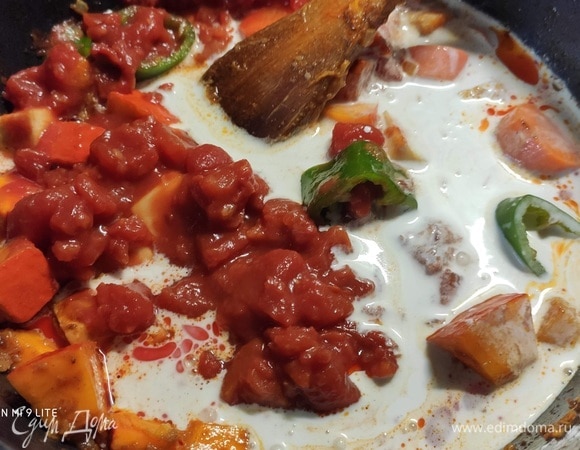 Добавить помидоры в собственном соку, предварительно их измельчив, кокосовое молоко и овощной бульон и дать всему медленно покипеть в течение 20–25 минут. Время от времени помешивать.