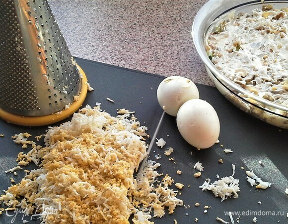 Пятый слой — отварные яйца. Яйца натереть на средней терке. Посыпать на жареный лук.