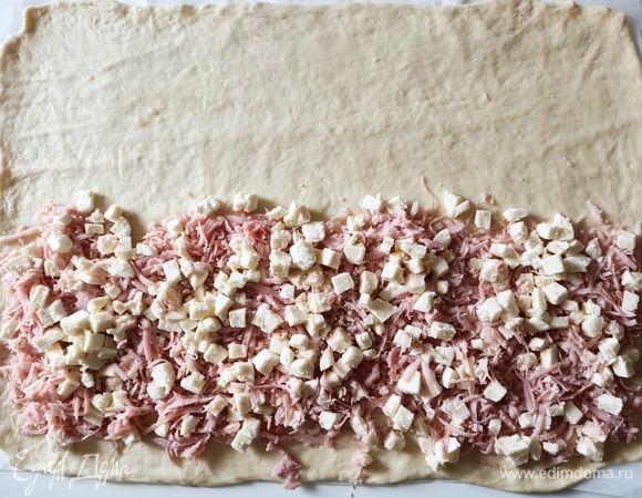 Готовое тесто раскатать в прямоугольник. До середины выложить начинку.