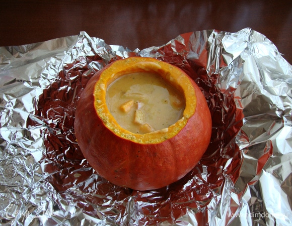 Суп перелить в подготовленную тыкву, накрыть крышкой- хвостиком. Завернуть в фольгу и поставить томиться в разогретую до 190–200°C духовку примерно на 50 минут.