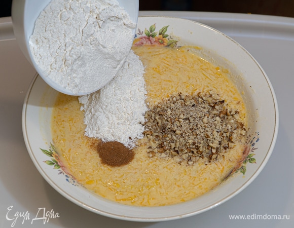 Муку просеять с разрыхлителем теста. Всыпать в тыквенную массу сухую мучную смесь, измельченные грецкие орехи и молотую корицу.