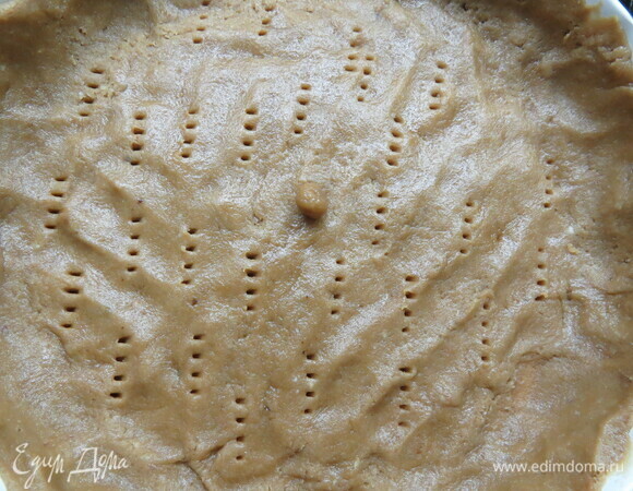 Тесто раскатать и выложить в форму (22 см), наколоть вилкой. Поставить форму в разогретую до 180°C духовку и выпекать 10–12 минут.