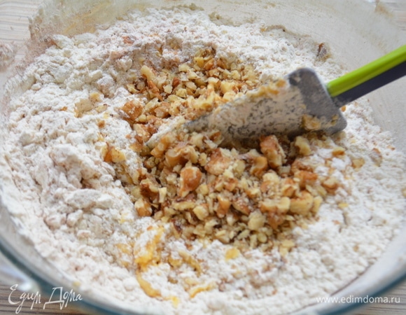 К масляной массе добавить мучную смесь и измельченные орехи, перемешать лопаткой.