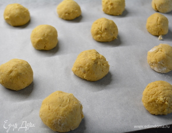 По истечении времени достать тесто. Скатать шарики размером с грецкий орех. Выложить на противень.