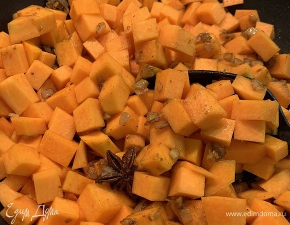 Добавить в сотейник нарезанную тыкву и обжарить 1 минуту. Влить воду и довести до кипения. Убавить огонь и накрыть крышкой. Потушить минут 10, пока тыква не станет мягкой.
