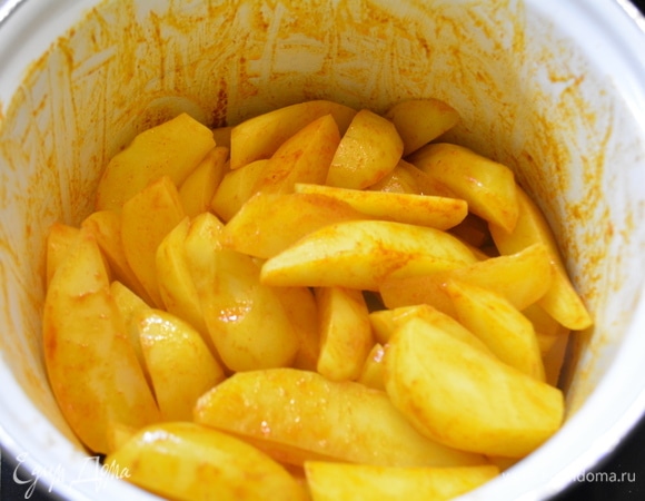 Полить картофель пряным маслом, закрыть крышкой и встряхнуть ее, чтобы все ломтики оказались в масле.