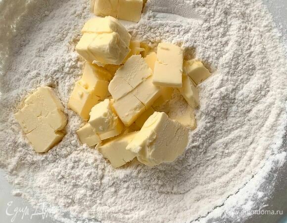 В миске смешайте пшеничную муку (просейте), сахарную пудру, разрыхлитель и щепотку соли. Холодное сливочное масло нарежьте кубиком и добавьте к муке. Перетрите тесто в крошку.