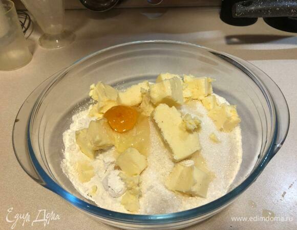 Муку смешать с сахаром, выложить порубленное кусочками масло, добавить соль, яйцо, замесить хорошо тесто.