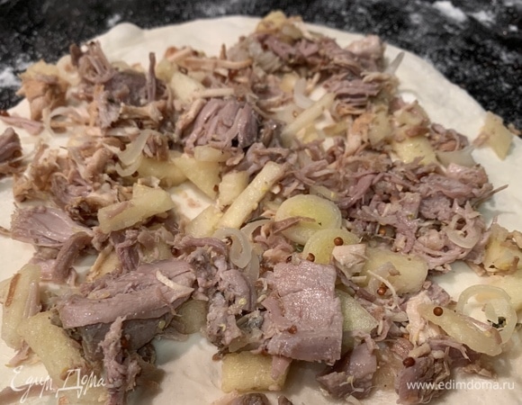 Раскатайте половину теста в пласт толщиной 1 см. Равномерно выложите половину начинки, края смажьте яйцом и плотно заверните в рулет, разрежьте на три части. Также заверните второй рулет.