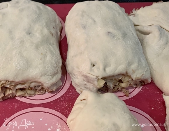 Выложите рулетики на противень, застеленный пергаментом или силиконовым ковриком. Смажьте рулеты взбитым яйцом. Запекайте в предварительно нагретой до 180°C духовке 25 минут.