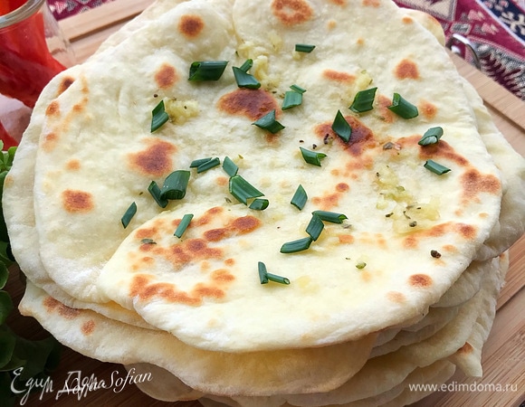 Готовую лепешку переложить на доску и смазать чесночным маслом. Приготовим чесночное масло: чеснок выдавить через пресс, добавить орегано, соль, масло и перемешать.