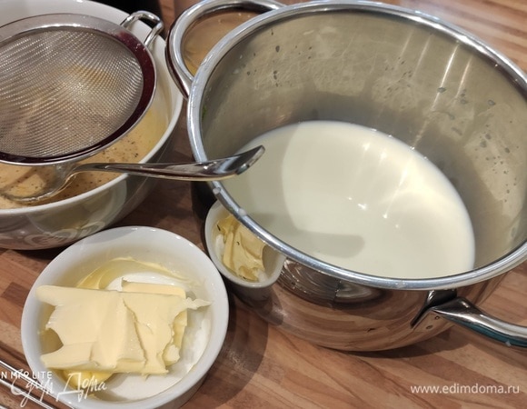 Горячее молоко процедить через мелкое сито и сразу тонкой струйкой влить в смесь яичных желтков, тщательно размешать.