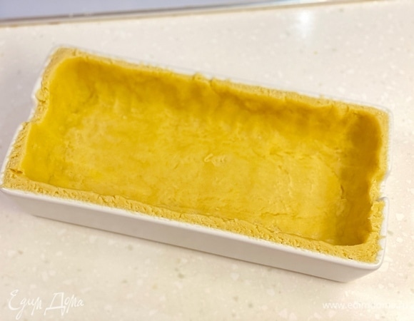 В форме для запекания сформировать из теста основу для пирога. Убрать в холодильник на 30 минут.