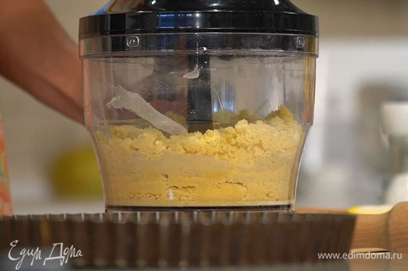 Муку, предварительно размягченное сливочное масло и сахарную пудру поместить в чашу блендера, добавить яичные желтки, соль и измельчить все в крошку, а затем выложить на рабочую поверхность.