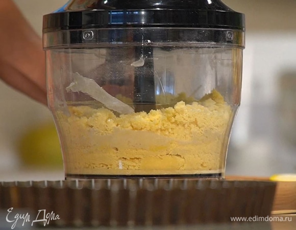 Муку, предварительно размягченное сливочное масло и сахарную пудру поместить в чашу блендера, добавить яичные желтки, соль и измельчить все в крошку, а затем выложить на рабочую поверхность.