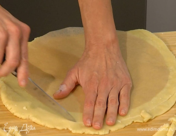 Вымесить тесто руками и раскатать в тонкий корж, края обрезать так, чтобы корж был на полтора сантиметра больше формы.
