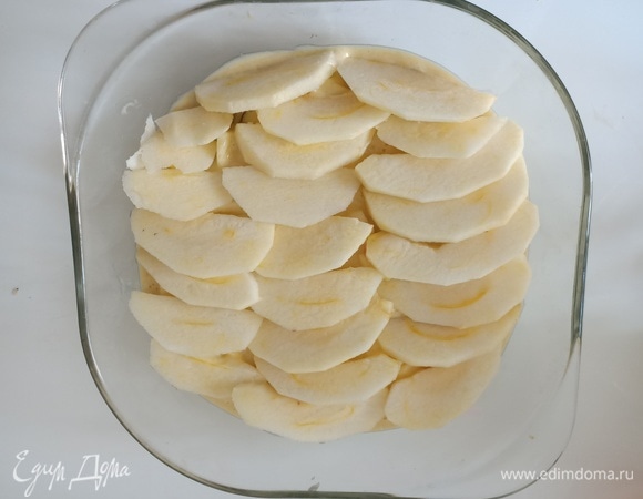 Тесто выложить в стеклянную форму для микроволновой печи, сверху выложить нарезанное яблоко.