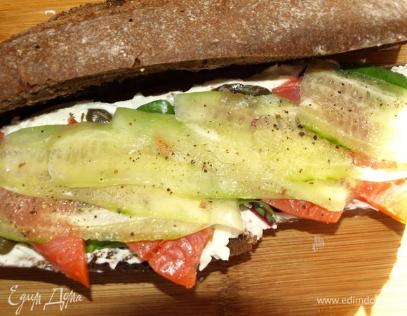 Огурец очистить. Овощечисткой нарезать на тонкие полоски. Выкладываем на семгу и добавляем по вкусу черный молотый перец.